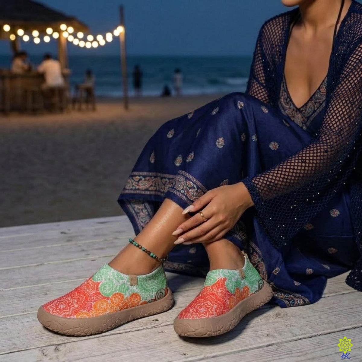 Scarpe slip-on a mandala indossate con un abito blu navy in spiaggia di notte