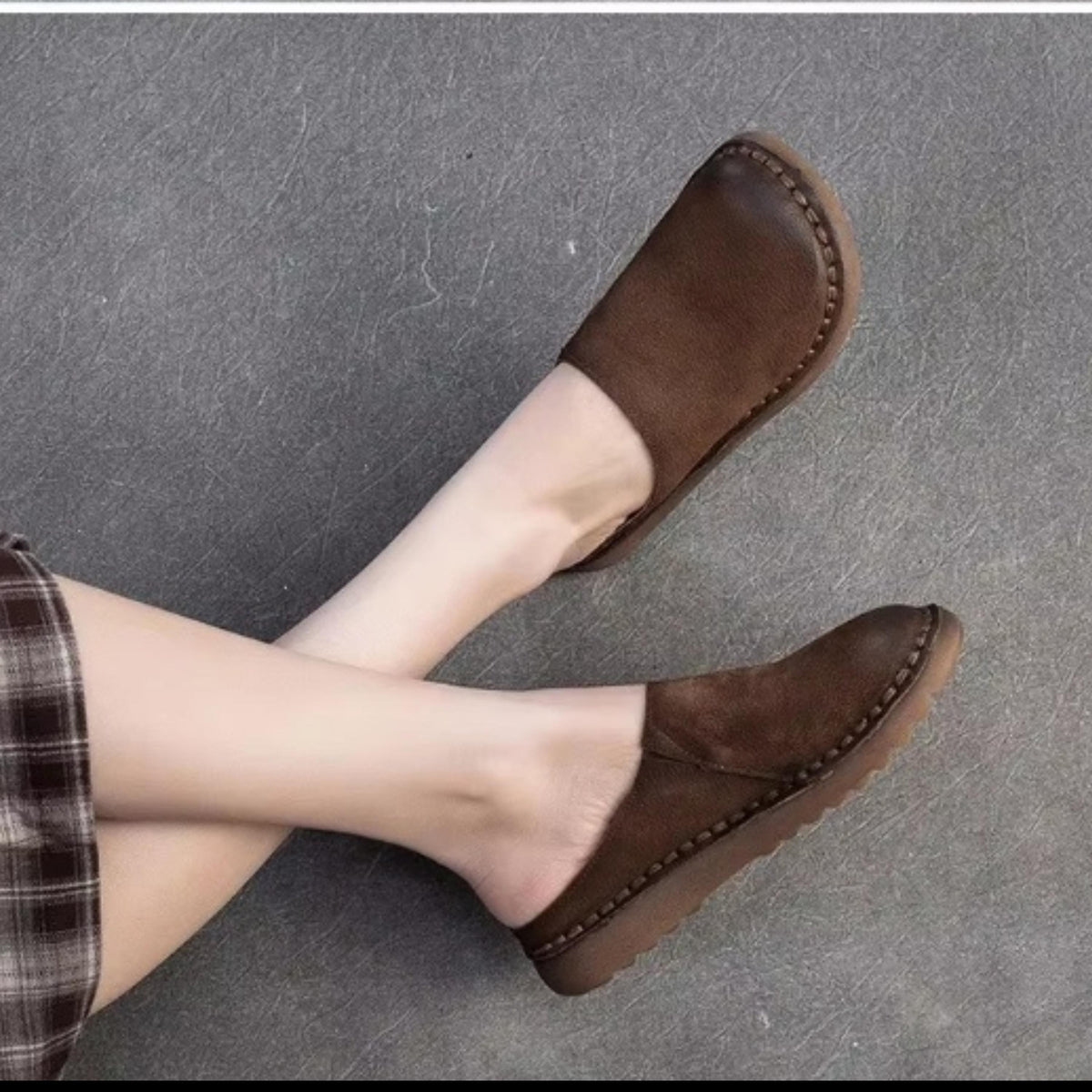 A pair of brown leather slip-on shoes with a simple, classic design.