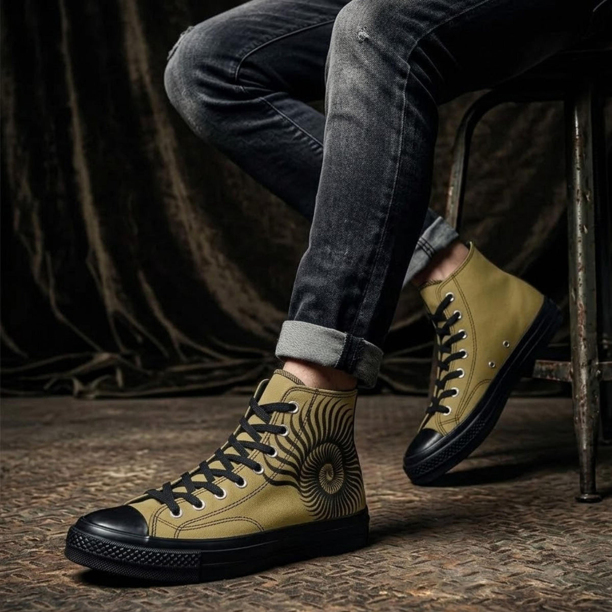 A person wearing yellow and black sneakers with a sun design on the side, sitting on a chair.