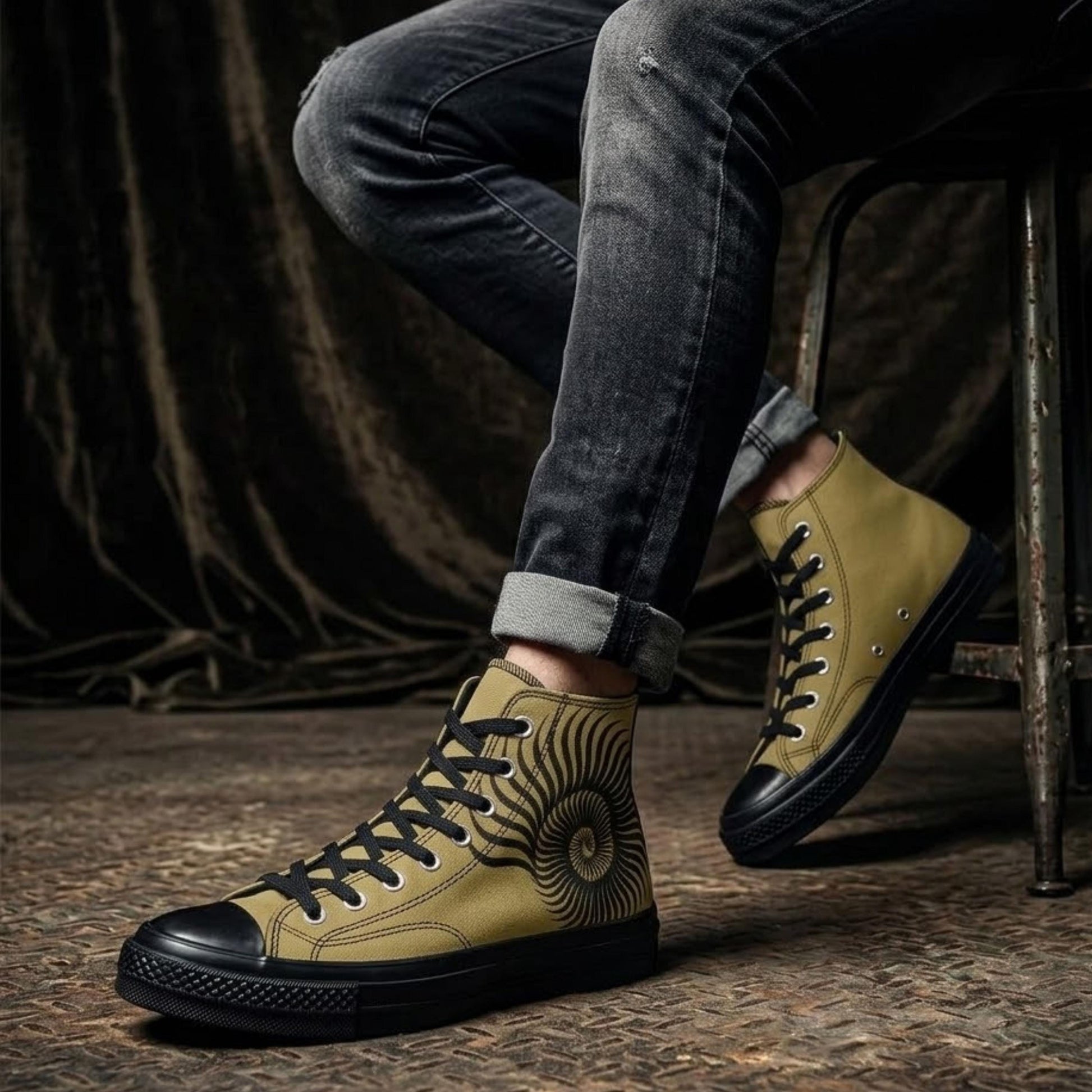 A person wearing yellow and black sneakers with a sun design on the side, sitting on a chair.