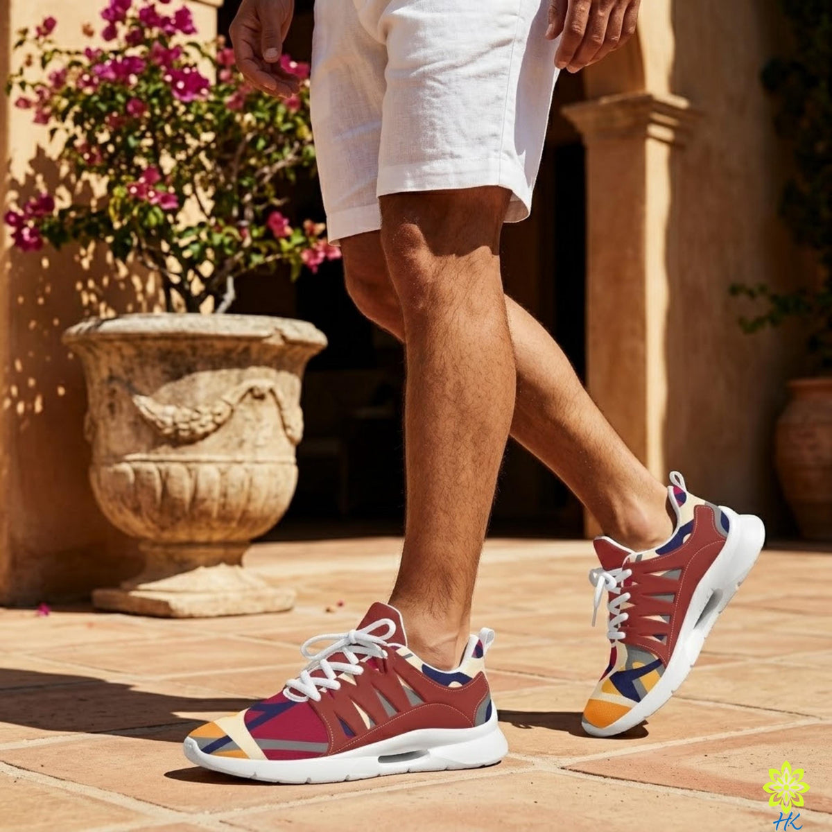 A person wearing colorful sneakers is walking on a tiled floor in front of a building with a potted plant.